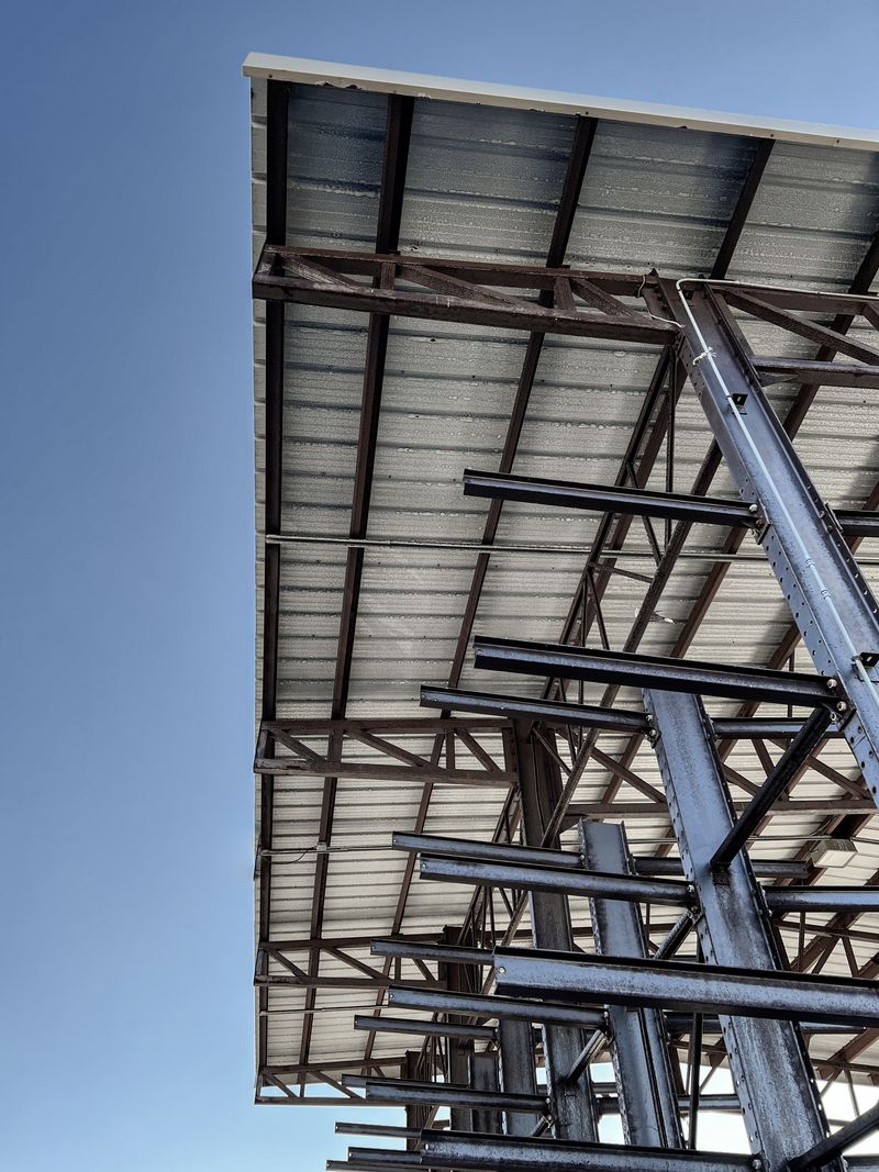 Industrial structural steel framework and beams during construction against a clear blue sky