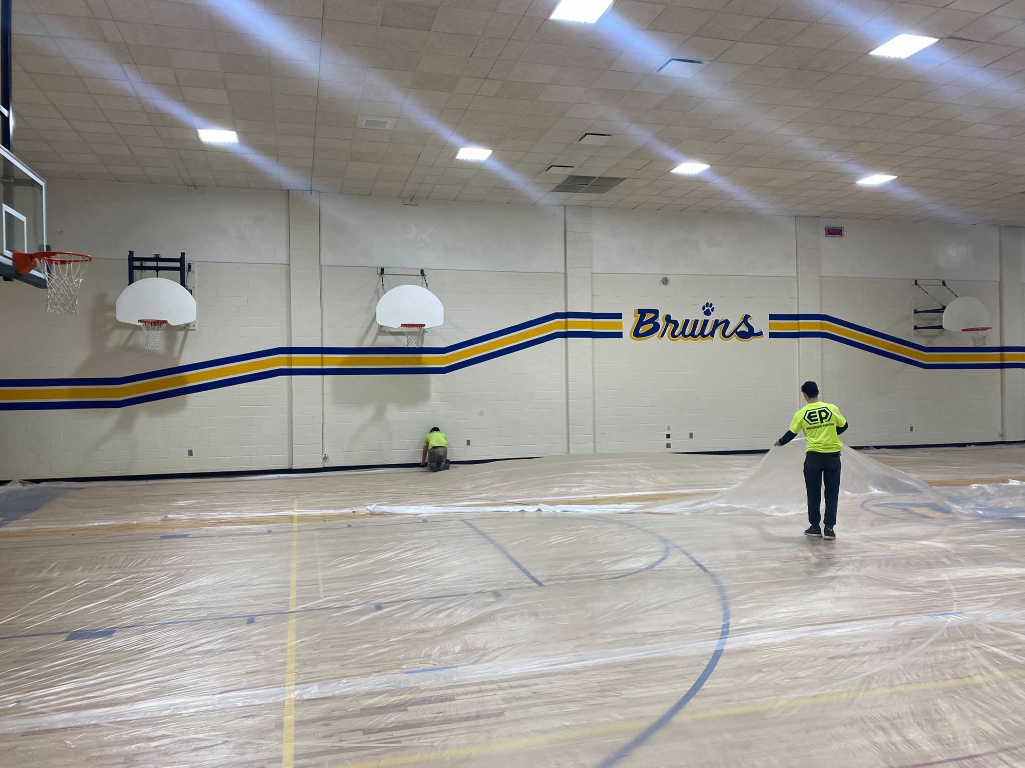 EP crew painting Bruins lettering and blue-gold stripe band
