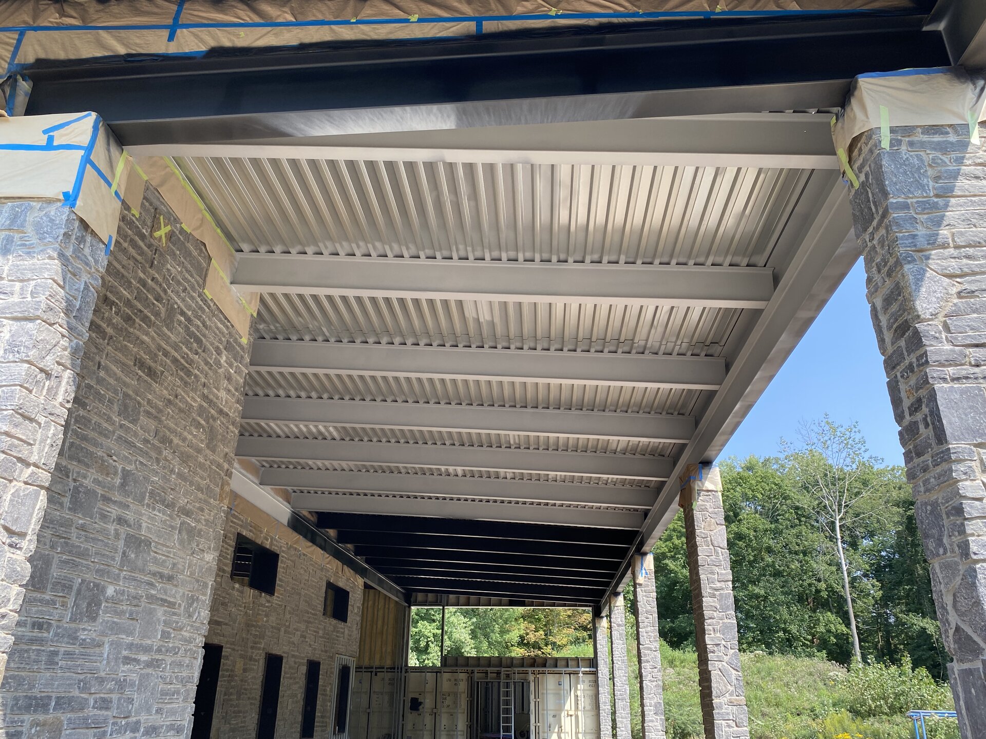 Painted structural steel deck underside — finished black beams and corrugated ceiling