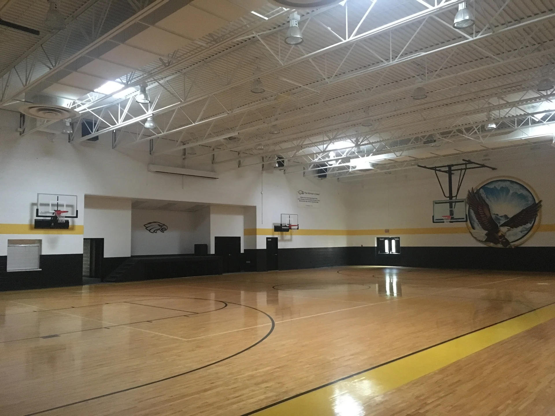 Faith of Davison gymnasium completed — black wainscot, gold stripe, and white upper walls