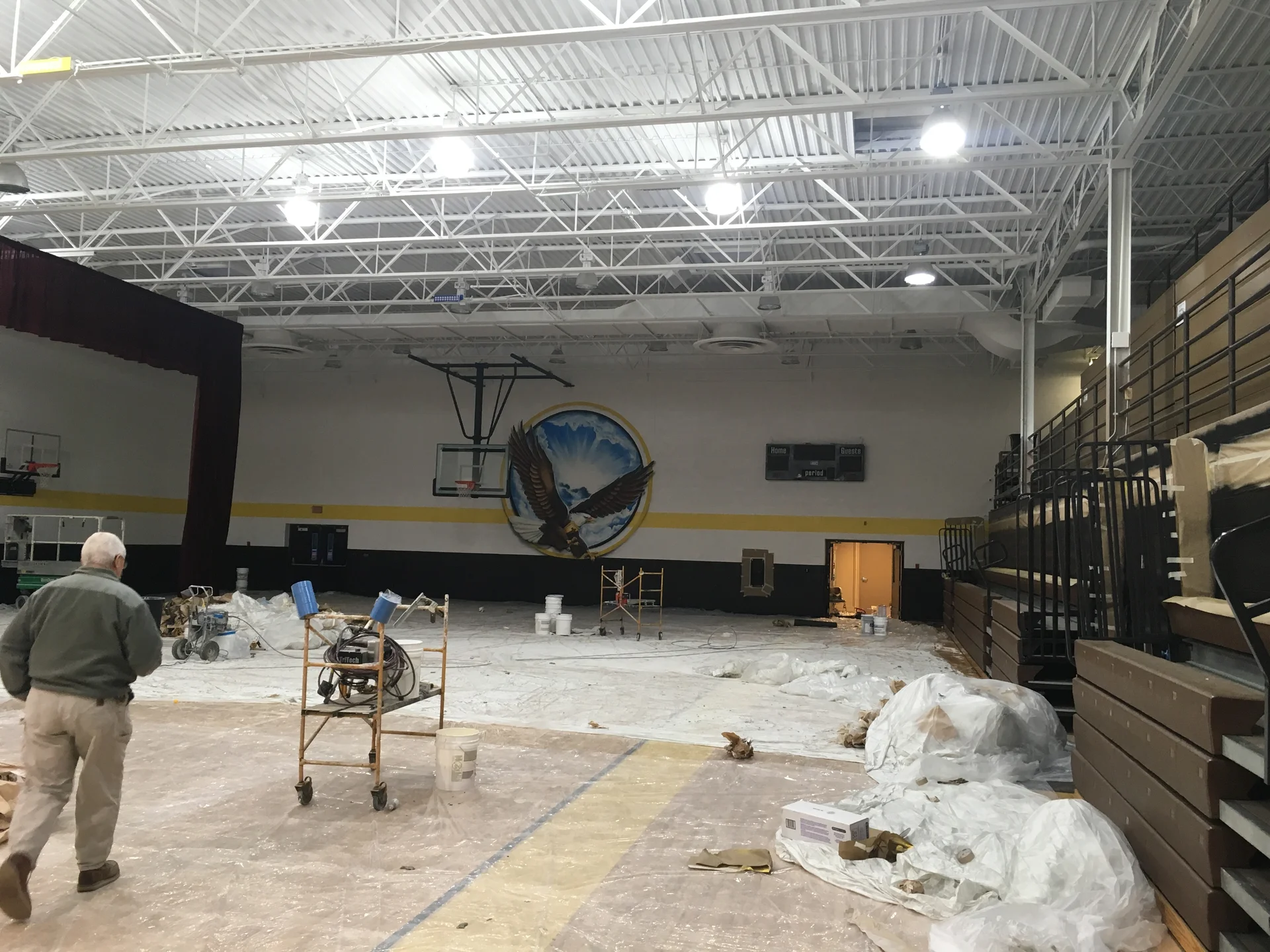 Endurance Painting crew mid-project — spray equipment set up, entire gymnasium floor protected