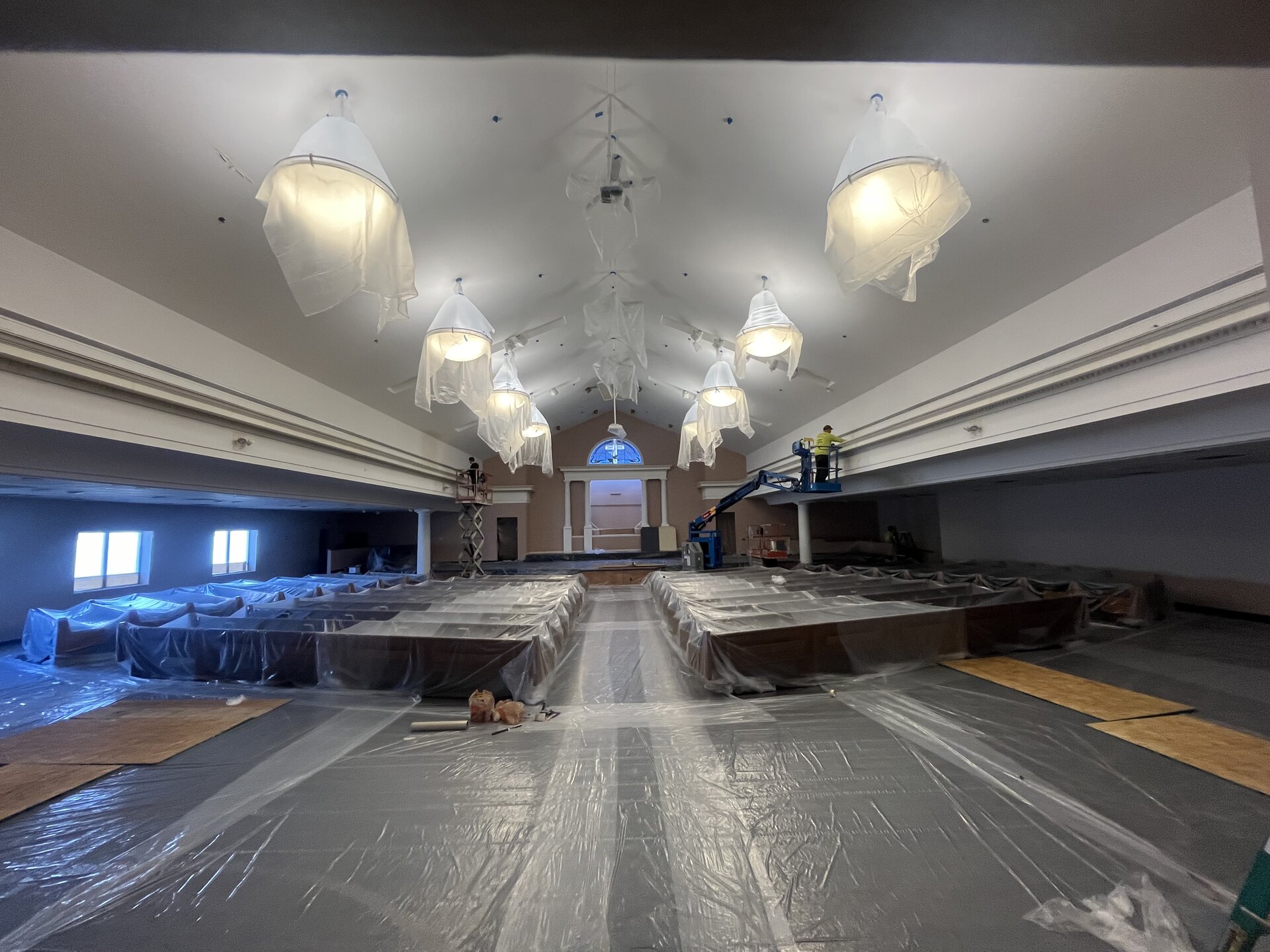 Church auditorium repaint — spray application on upper walls