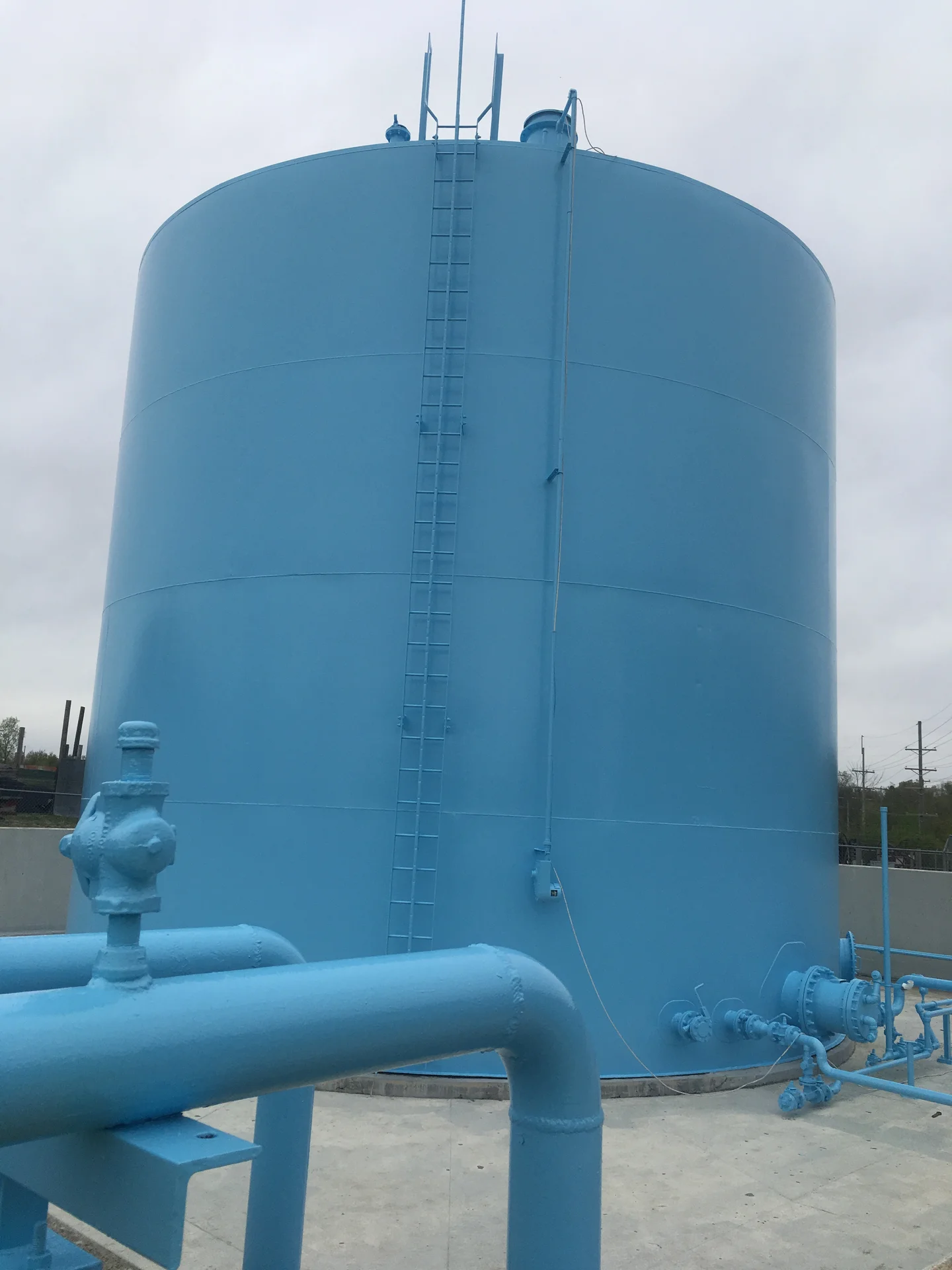 Wide view of the tank exterior with rooftop piping and railings