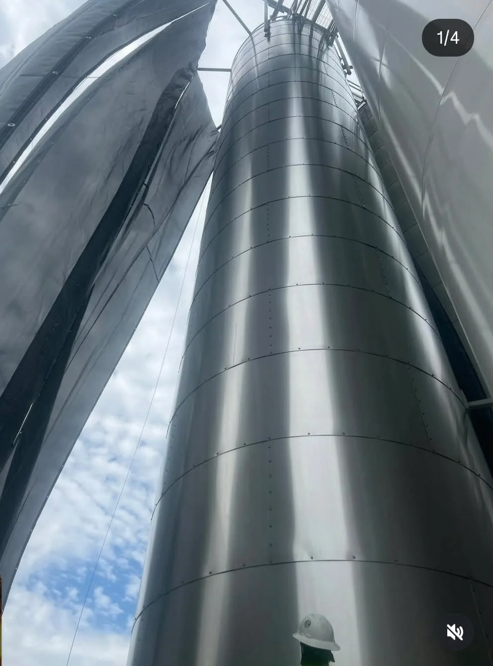 Looking up at the towering silos from ground level, showing the full scale of the tank farm