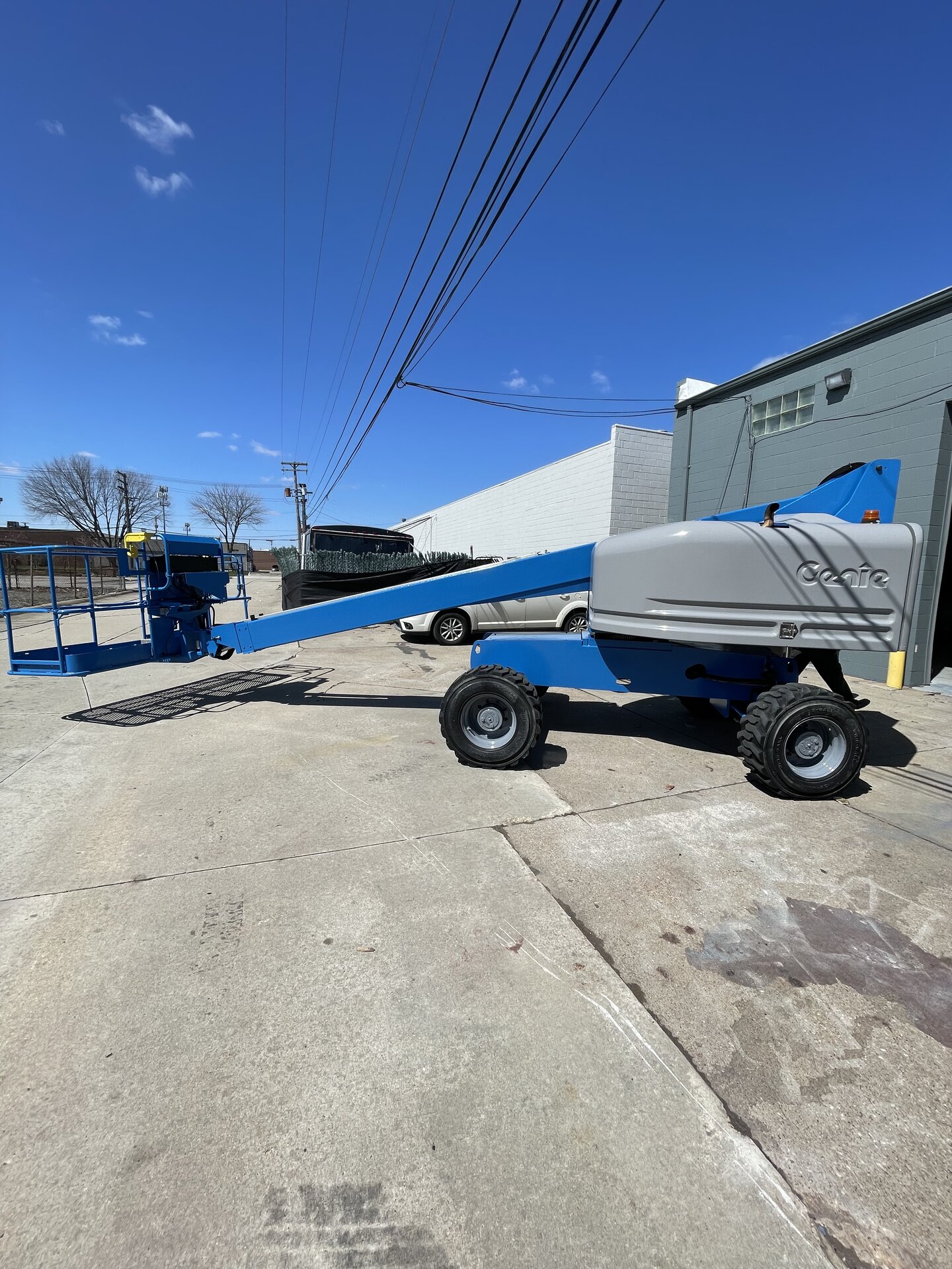 Equipment repaint in progress — spray application on boom section