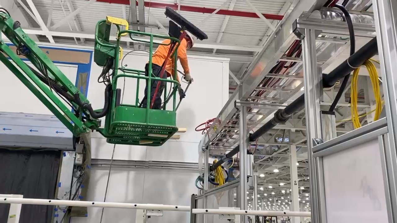 Rivian robotic assembly room — blast and paint on scissor lift
