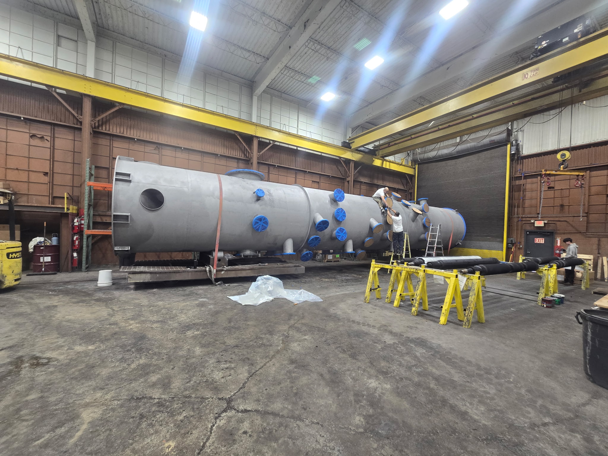 Multiple silos in shop with crew applying specialty coating