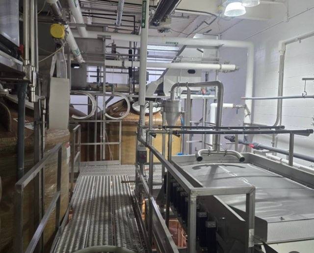 Piping and stainless equipment alongside freshly painted walls